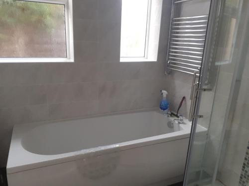 een badkamer met een wit bad en een raam bij silver way in Highcliffe