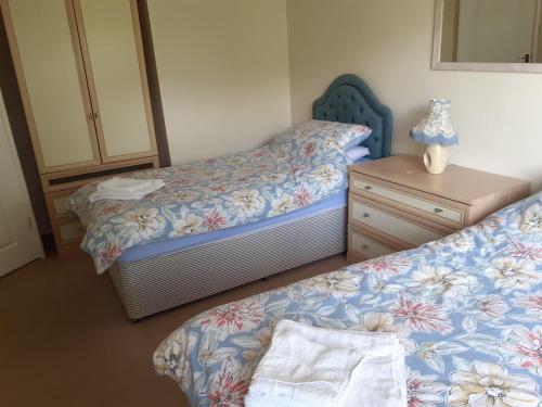 een kleine slaapkamer met 2 bedden en een dressoir bij silver way in Highcliffe