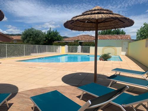 a pool with an umbrella and chairs and a swimming pool at Aux couleurs d’Ardèche in Vallon-Pont-dʼArc