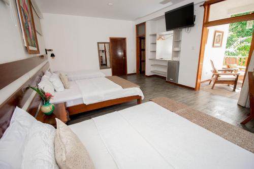 a living room with two beds and a television at Villa Lu Amazon Ecolodge in Tarapoto