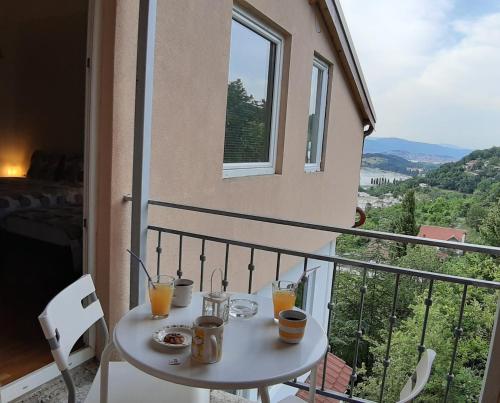 a table with two glasses of orange juice on a balcony at Villa Chingo in Ohrid