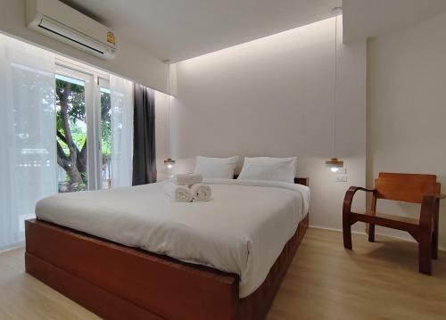 a bedroom with a large bed with two towels on it at Sense of Haiya in Chiang Mai