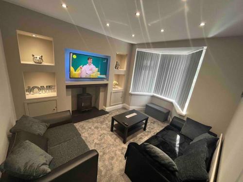 a living room with a couch and a flat screen tv at Modern Family home large garden free parking in Newcastle upon Tyne