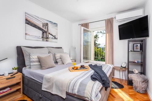 1 dormitorio con 1 cama grande y TV en Apartment Carovo7, en Kraljevica