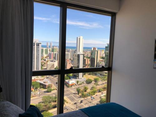 a view of a city from a bedroom window at Flat Versatti - Próximo Real Hospital Port e Pólo Médico Ilha do Leite in Recife