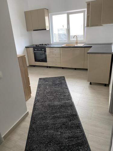 una cocina con alfombra negra en el suelo en Apartament, en Techirghiol