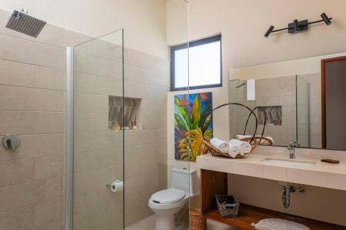 uma casa de banho com um WC, um lavatório e um chuveiro em Wonderful Tropical Home 3BR, Garden, Private Pool. em Tulum