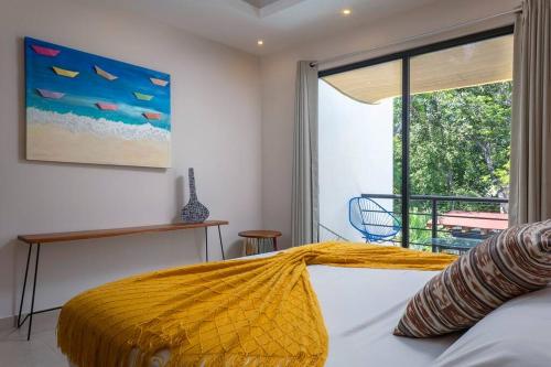 Un dormitorio con una cama con una manta amarilla. en Wonderful Tropical Home 3BR, Garden, Private Pool. en Tulum