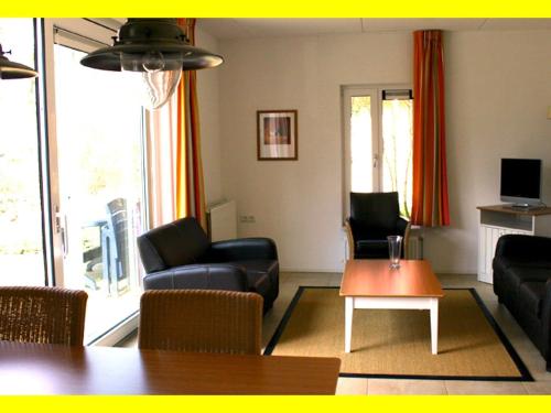 een woonkamer met een bank en een tafel bij Cozy apartment in a farmhouse in Camino-Ombra in Westerbork