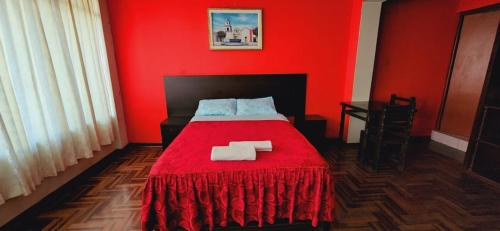a red bedroom with a bed with a red blanket at HOSPEDAJE CALLAO in Tacna