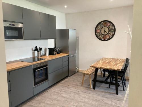 een keuken met een tafel en een klok aan de muur bij T2 Le Conquet "Molène" avec parking privé 300m commerces in Le Conquet