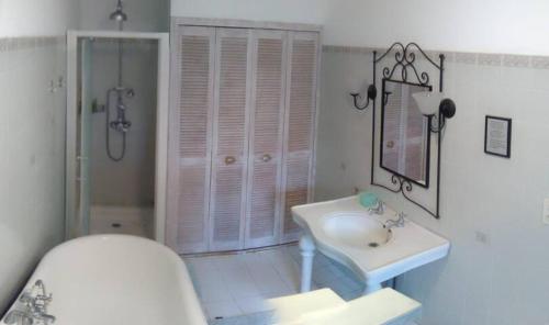 a white bathroom with a sink and a shower at Quaint and original loft room 