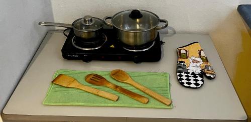 a stove top with wooden utensils and a pot on a stove at VANILLA appartment in Ciudad Hidalgo