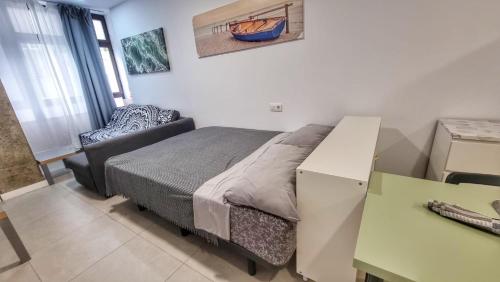 ein kleines Schlafzimmer mit einem Bett und einem Stuhl in der Unterkunft Playa de Las Canteras & Puerto Loft in Las Palmas de Gran Canaria
