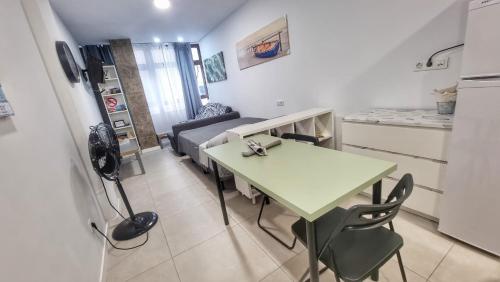 ein Wohnzimmer mit einem Tisch und einer Küche in der Unterkunft Playa de Las Canteras & Puerto Loft in Las Palmas de Gran Canaria