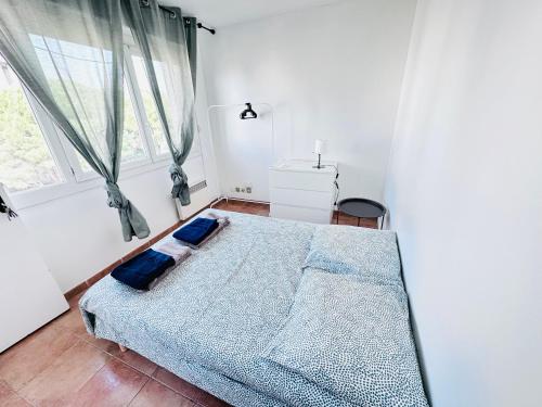 een slaapkamer met een bed met blauwe lakens en een raam bij Chambres à louer dans appartement in Montpellier