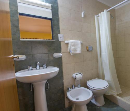 a bathroom with a sink and a toilet and a mirror at Bari in Mendoza