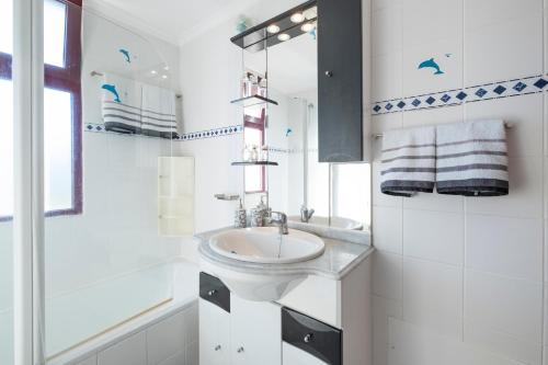 een witte badkamer met een wastafel en een spiegel bij Terrace to Atlantic in Santa Cruz