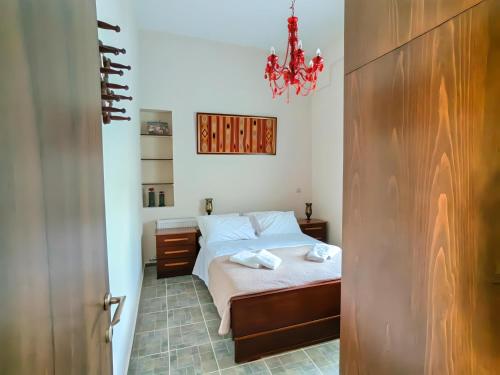 a small bedroom with a bed and a chandelier at Villa Nelparadi in Plátanos