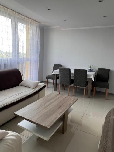 sala de estar con sofá, mesa y sillas en Look of Dreams - Apartament w Superjednostce, en Dąbrowa Górnicza