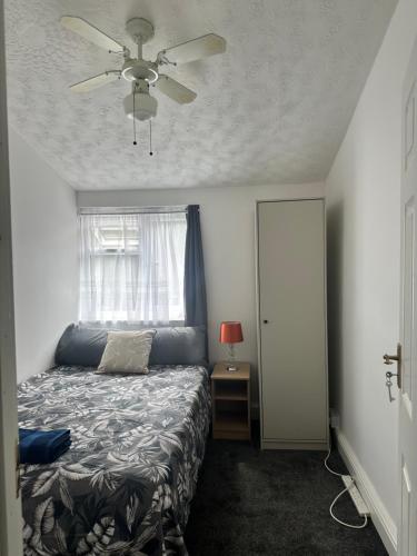 a bedroom with a bed and a ceiling fan at Charming Four Bedroom Holiday Home in Harlow