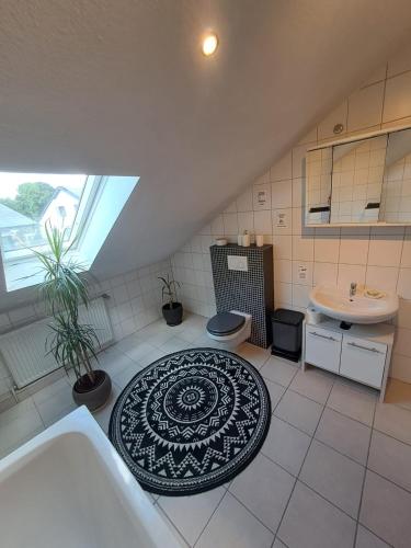 a bathroom with a sink and a toilet and a tub at Ferienwohnung mit Weitblick in Nordhessen in Gudensberg