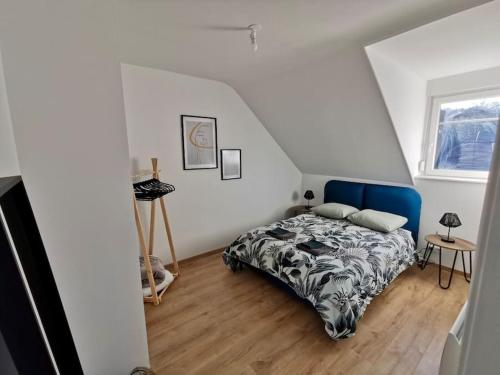 een slaapkamer met een bed met een blauw hoofdeinde bij ÉVASION JUNGLE - Wifi & Netflix ! in Mulhouse