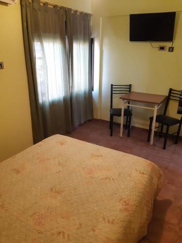 a bedroom with a bed and a table with chairs at Bari in Mendoza