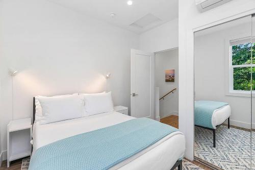 een witte slaapkamer met een bed en een raam bij The Greenwood Gem in Seattle