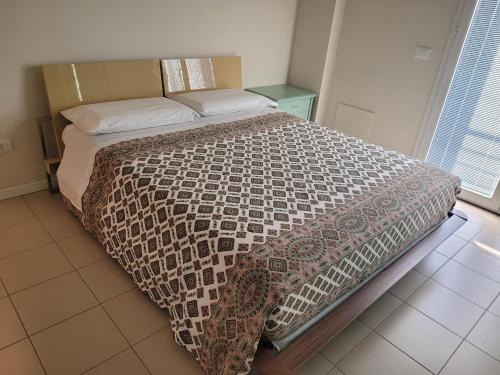a bedroom with a bed with a brown and white comforter at Appartamento A in Gradara