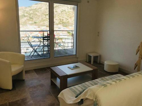 une chambre avec un lit, une table et une fenêtre dans l'établissement Maison avec magnifique vue mer - Les Goudes, à Marseille