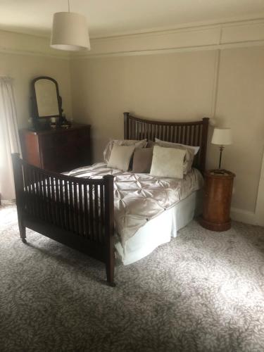 a bedroom with a bed with pillows and a mirror at Larchgrove - 1800s Irish Farmhouse in Carlow