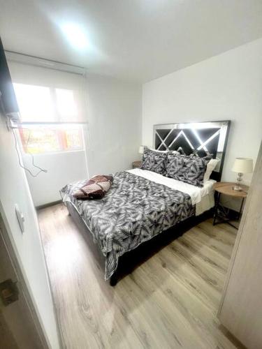 1 dormitorio con cama, mesa y ventana en *Hermoso y cómodo apartamento cerca al aeropuerto, en Bogotá