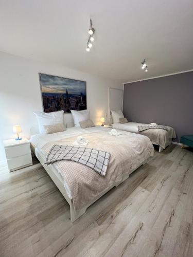 two beds in a bedroom with wooden floors at Home Inn Apartments - 201 in Minden
