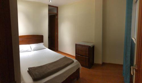 a bedroom with a bed and a dresser in it at Hermoso departamento en lugar centrico in Trujillo