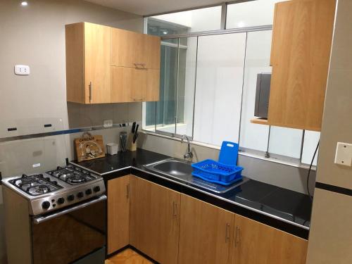 a small kitchen with a stove and a sink at Hermoso departamento en lugar centrico in Trujillo