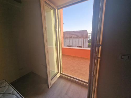 an open door to a balcony with a large window at Residence Mirella in Acquafredda