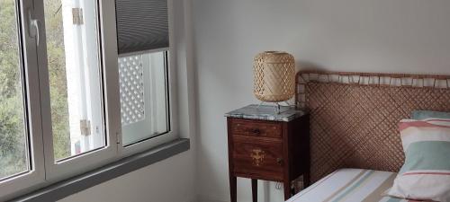 a bedroom with a bed and a nightstand next to a window at Cozy Room close to Cascais Downtown in Cascais
