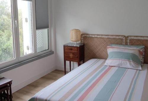 a bedroom with a bed and a dresser and a window at Cozy Room close to Cascais Downtown in Cascais
