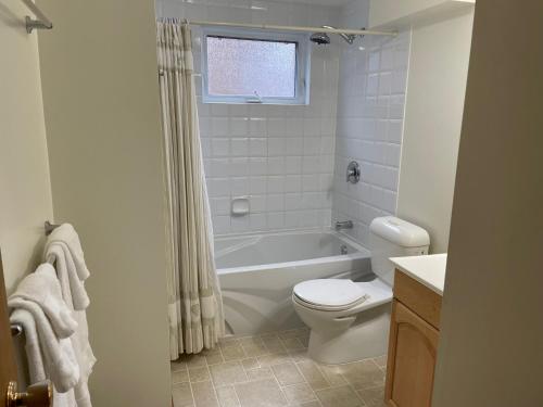 a bathroom with a tub and a toilet and a sink at Cedar House in Jasper