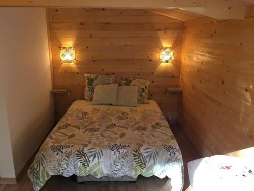 a bedroom with a bed in a wooden wall at Cabane au milieu des bois in Lanvellec
