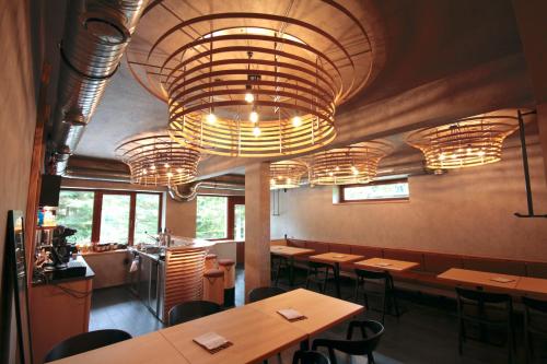 a restaurant with wooden tables and chairs and chandeliers at Horský hotel Brans in Malá Morávka