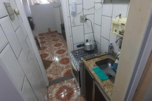 a small kitchen with a stove and a sink at STUDIO NITERÓI-BARCAS in Niterói