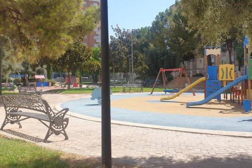 un parque con un banco frente a un parque infantil en Elda, Alicante, en Elda