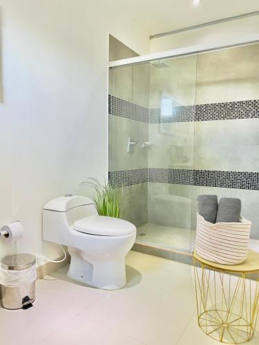 a bathroom with a toilet and a glass shower at Lago Calima Bliss: Secret Garden Paradise in Darien in Darién