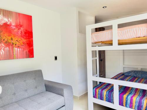 a living room with a couch and a bunk bed at Lago Calima Bliss: Secret Garden Paradise in Darien in Darién