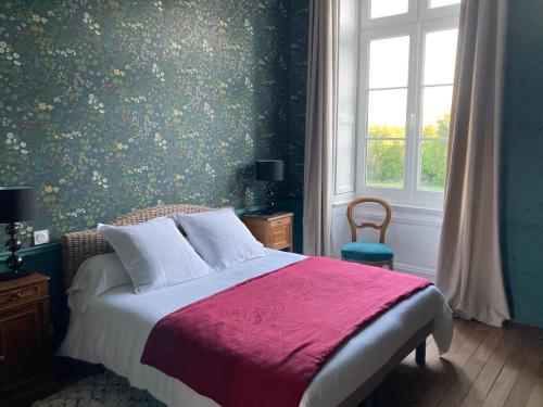 a bedroom with a bed with a red blanket and a window at Le Plessis in Orvault