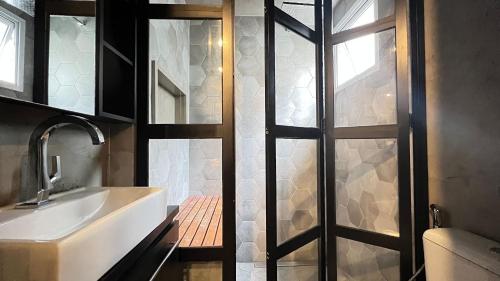 a bathroom with a sink and a glass door at MH 10201 - Estiloso Studio com WF/AC/Cama Queen in São Paulo