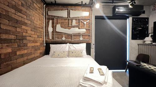 a bedroom with a bed with a brick wall at MH 10201 - Estiloso Studio com WF/AC/Cama Queen in São Paulo