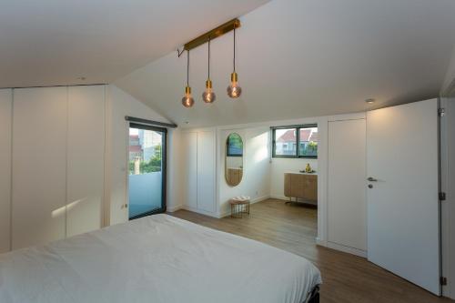 sypialnia z dużym białym łóżkiem i oknami w obiekcie Romantic Pool House w mieście Vila do Conde